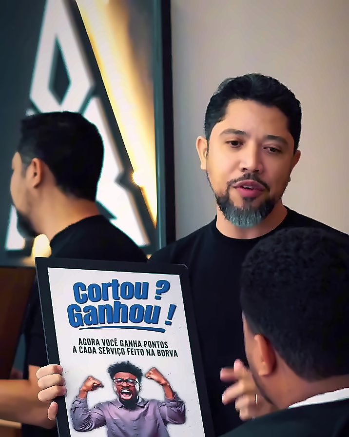 Barbeiro mostrando o cartaz Cortou? Ganhou! do programa de pontos da Borva